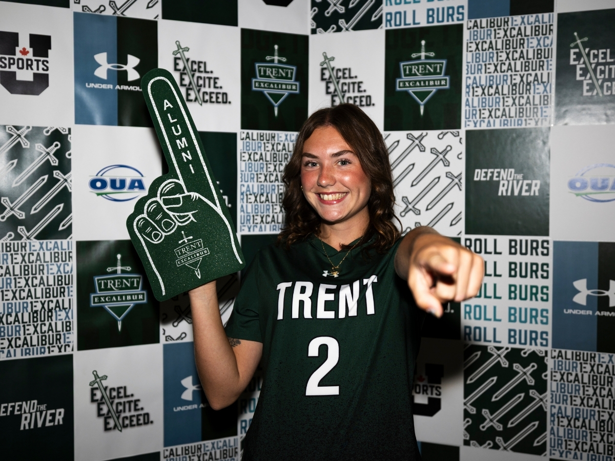A person pointing at the camera, holding up a foam finger