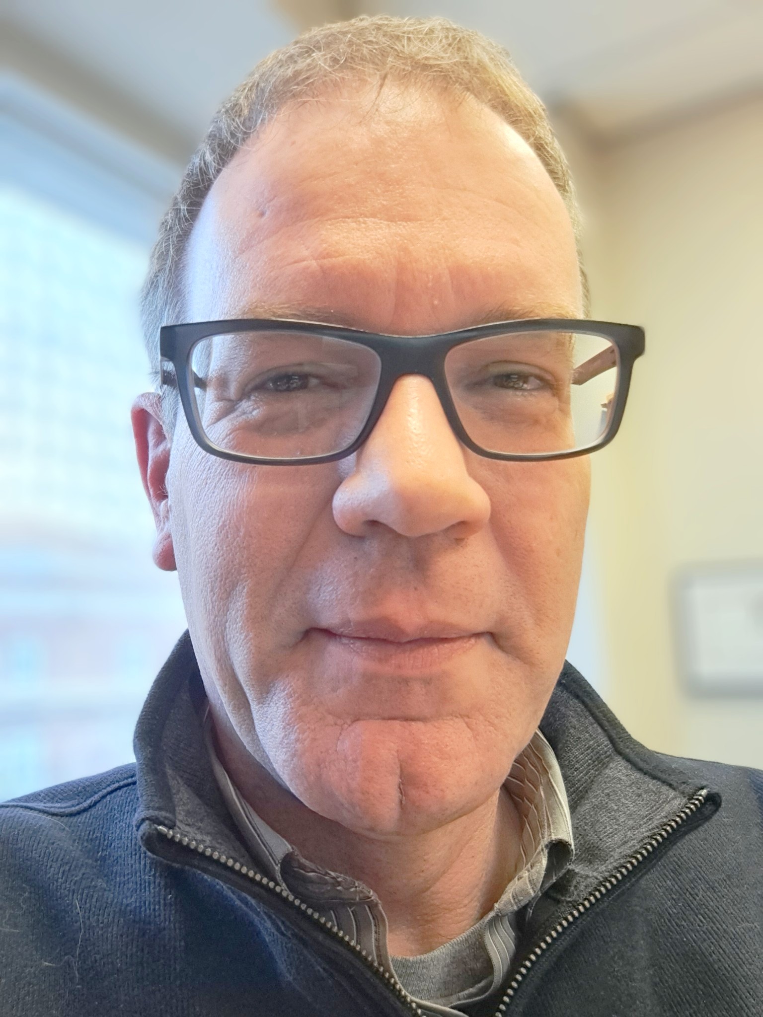 Picture of Dr. Klaas Kraay, wearing glasses, smiling at the camera