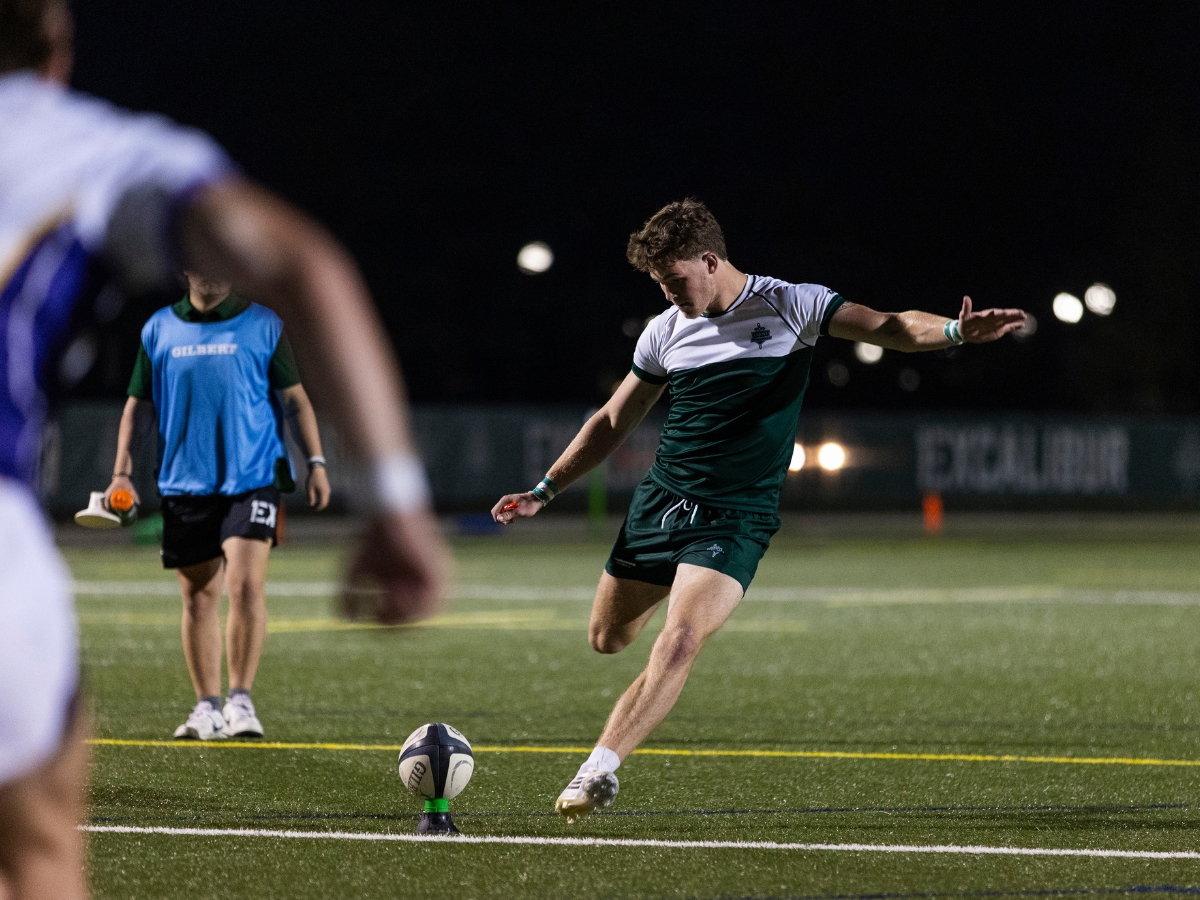 A player on the rugby field about to kick the ball