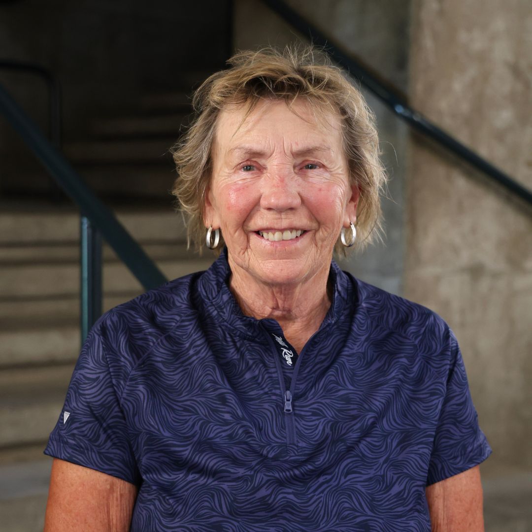 A woman in a blue top, smiling at the camera
