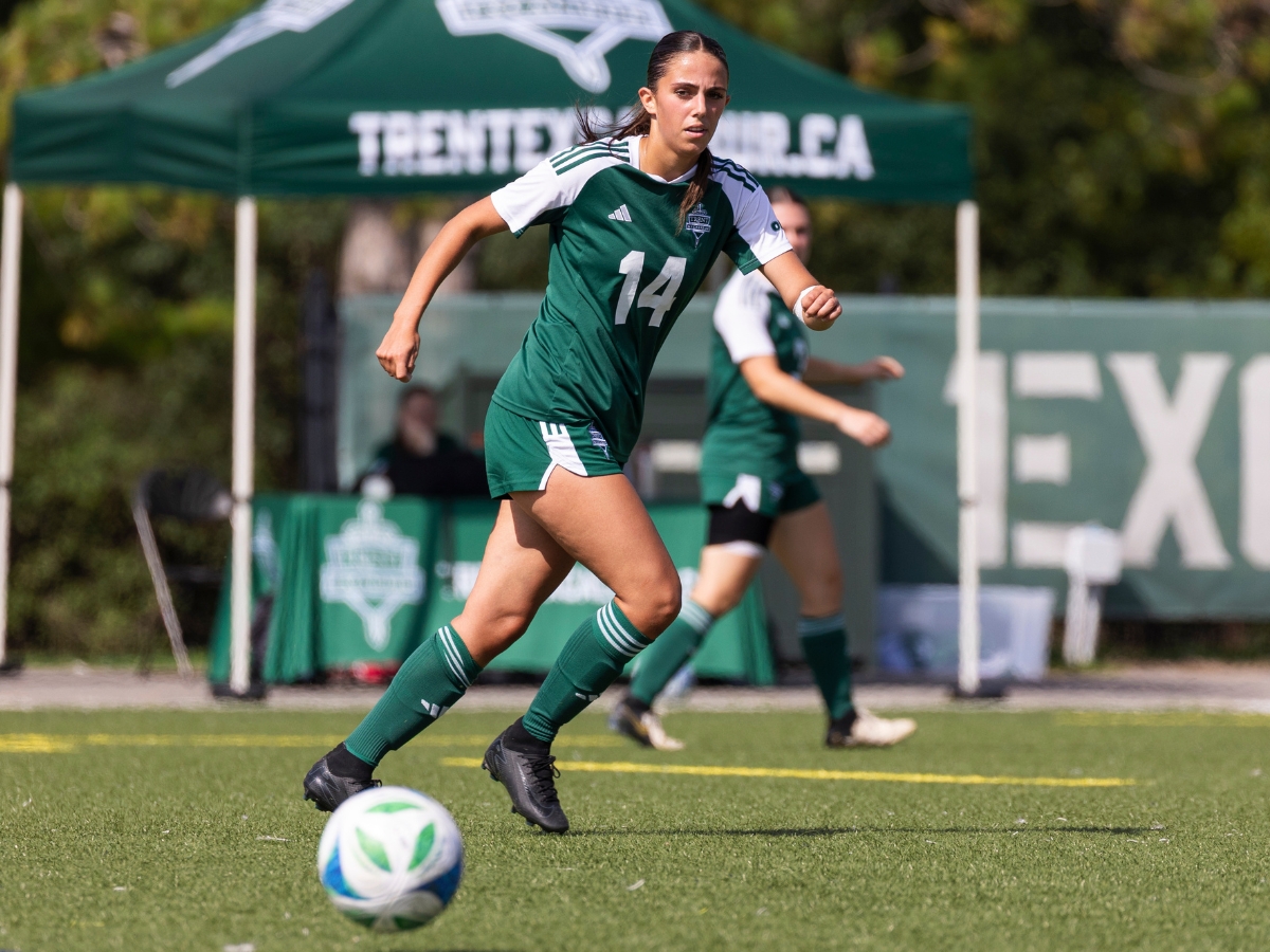 A focused soccer player running after the soccer ball