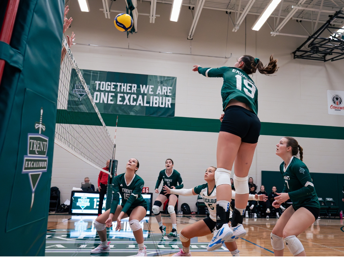 A woman spiking a volleyball on the court