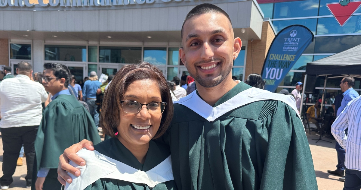 A mother and son hug in their Convocation gowns