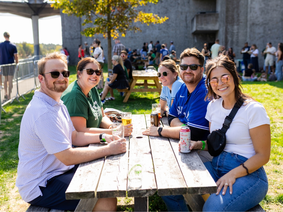 A group of people sitting outside at a picnic table