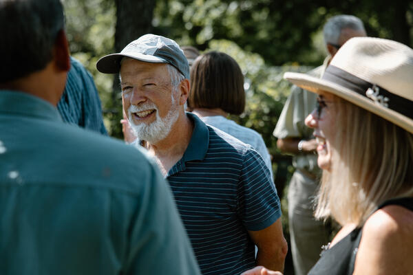 Retiree outside talking with two others