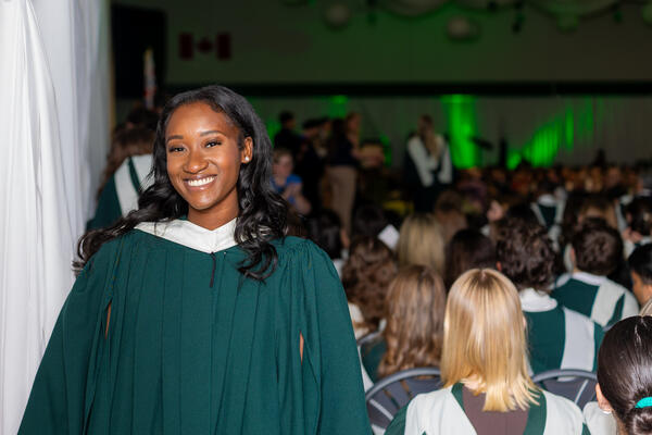 Women in graduation regalia smiling