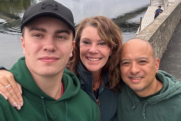 Angela Moore smiling next to her son and best friend