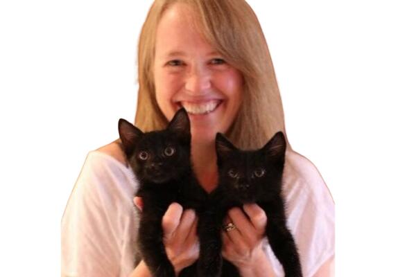 Karen Wickerson smiling and holding two black cats
