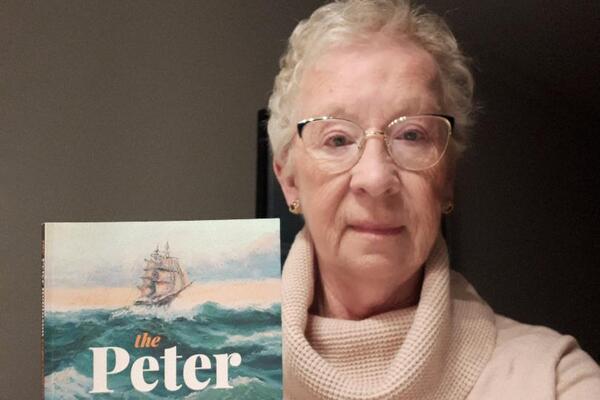 Woman holding her published book title the Peter Robinson Experiment