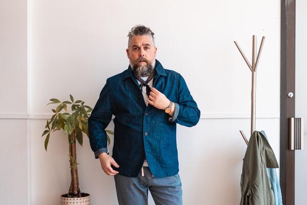 Man standing against a wall looking at the camera