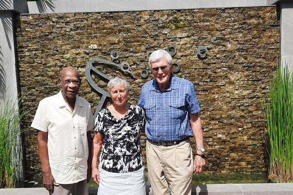 Three people standing outside smiling at the camera