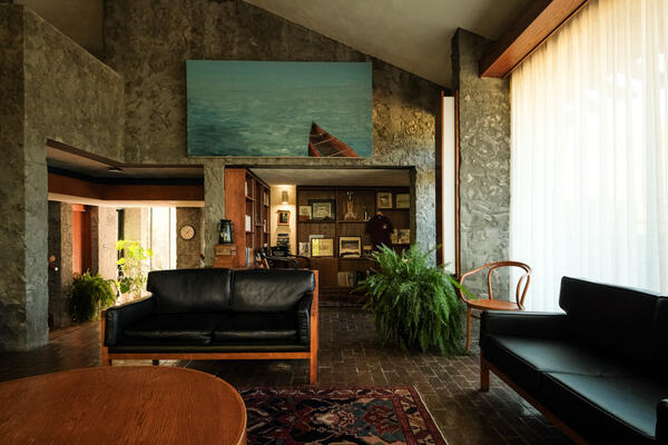 Alumni House living room, couches, art, plants fill the room