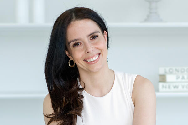 Woman in a white dress smiling at the camera