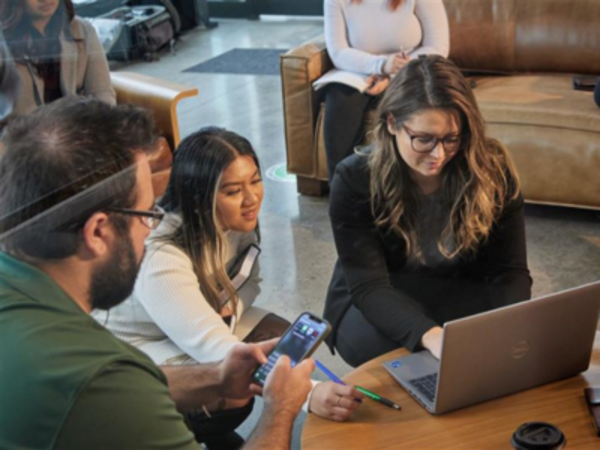 People gathered around a laptop