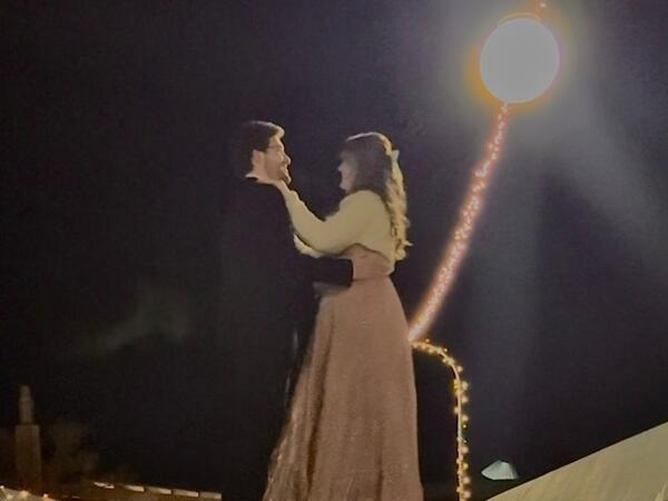 A couple dancing outside under twinkle lights