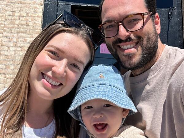Couple smiling with a baby in front of the Pig's Ear pub