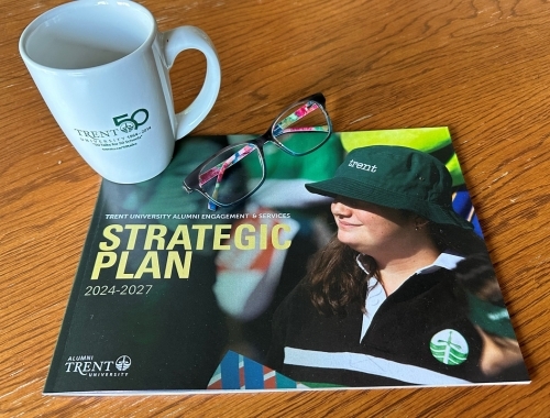 The strategic plan sits on a table with eyeglasses and a coffee mug. 