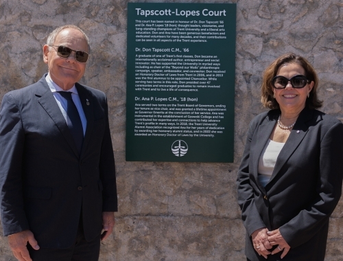 Dr. Don Tapscott and Dr. Ana Lopes stand smiling next to signage for Tapscott-Lopes Court. 