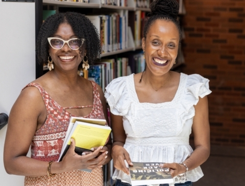 Dr. Adwoa Onuora, coordinator for the Black Studies specialization, stands next to student Sherri-Ann Emanuel in the Trent Durham GTA library
