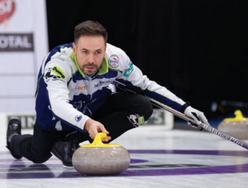 John Epping crouches down while curling