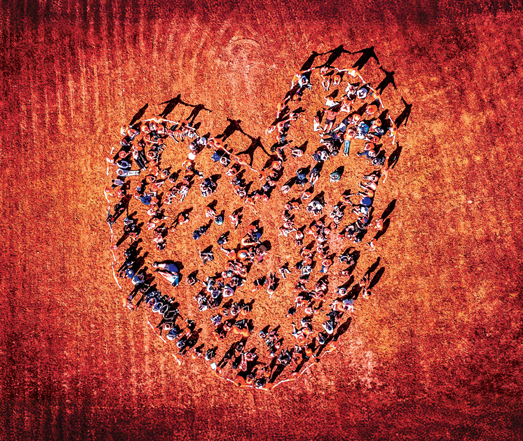 Group of people standing in the shape of a heart