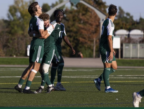 Members of the men's soccer team celebrate on the field