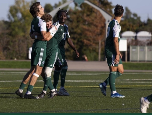Members of the men's soccer team celebrate on the field