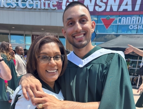 A mother and son hug in their Convocation gowns
