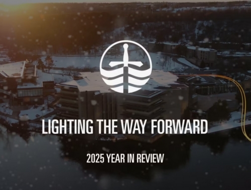 A drone shot of Trent University Peterborough Campus with the text "Lighting the Way Forward 2025 Year in Review" overtop