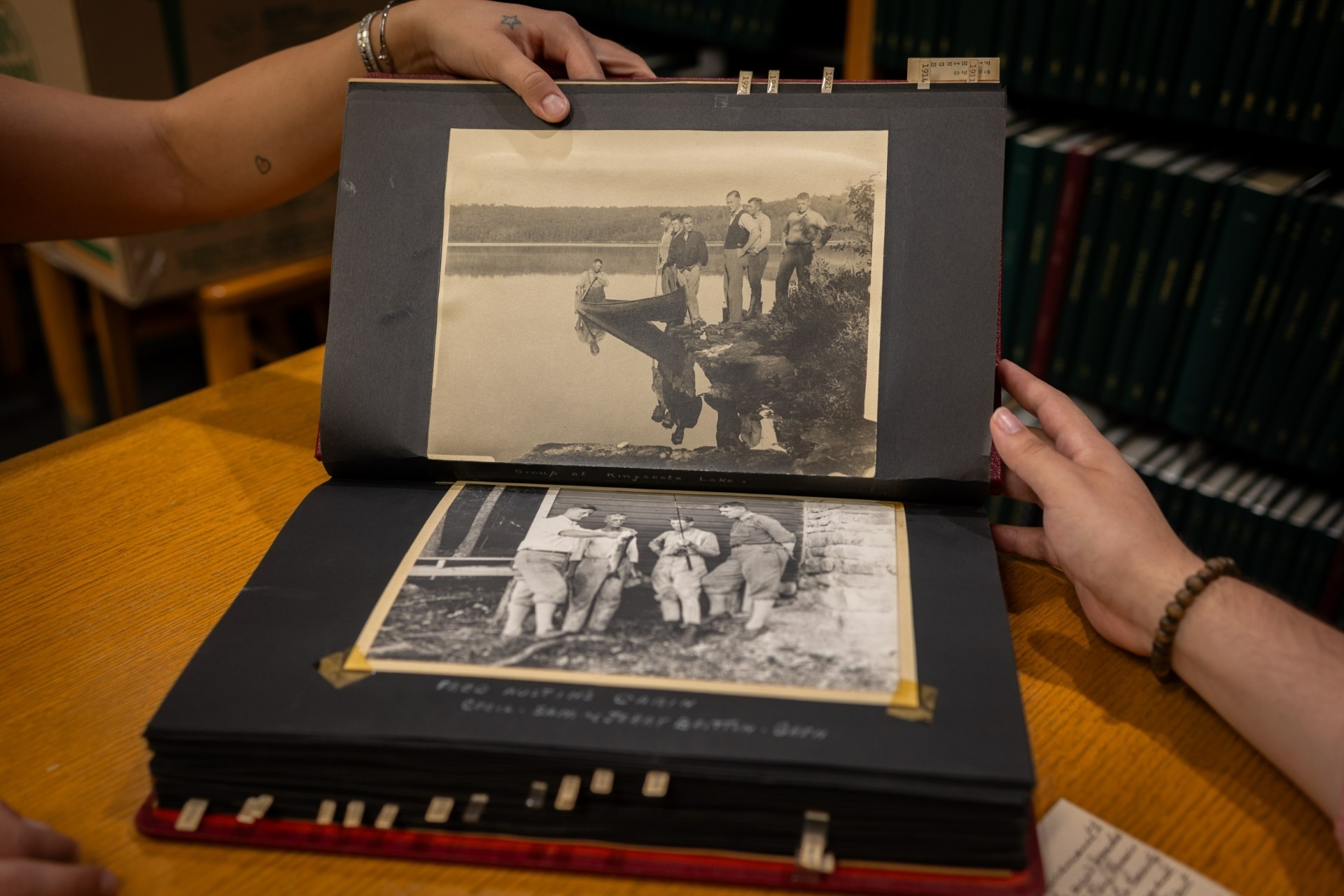 Archival photo album held open by two hands.