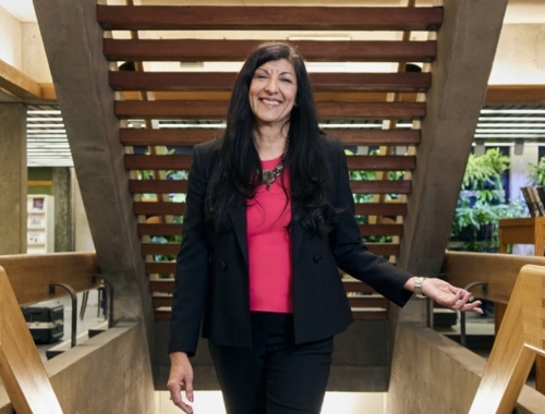 A woman standing under Bata Library staircase smiling at the camera