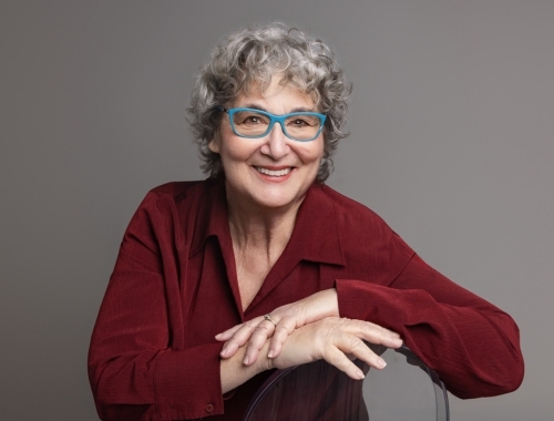 A woman sitting on a chair, smiling at the camera