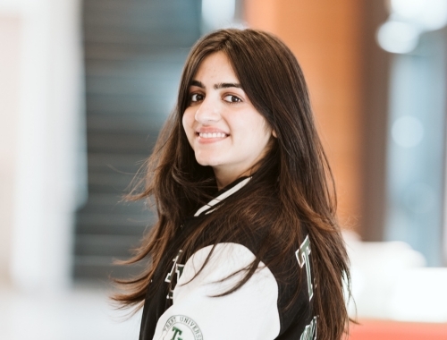 A woman wearing a Trent jacket, smiling at the camera