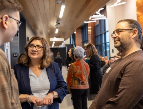 Group of people standing in a circle talking to each other