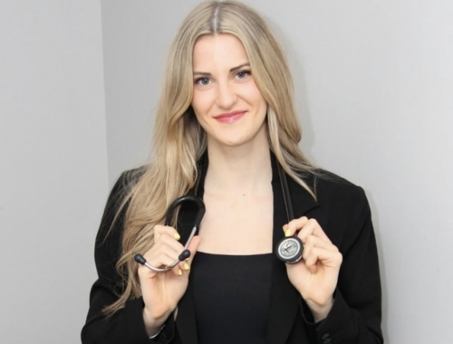 A woman looking at the camera with a stethoscope around her neck