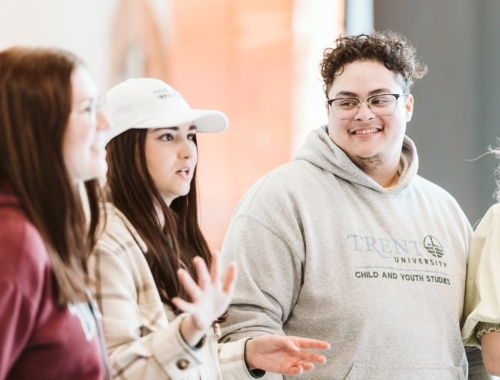 Three people standing in a conversation with each other
