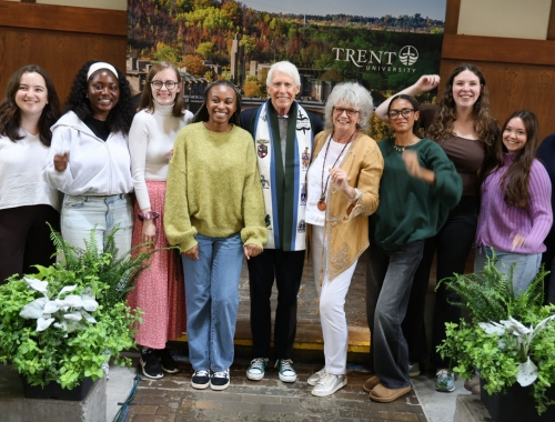 A group of students and two donors smile at the camera