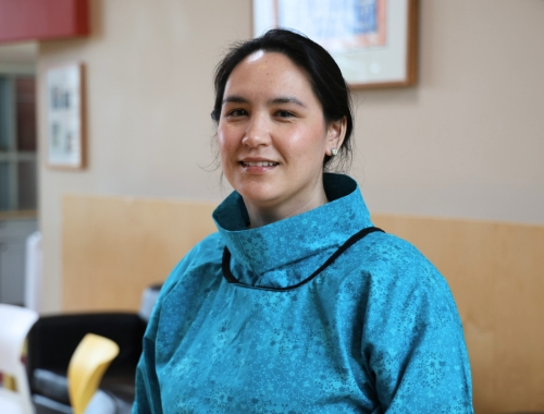 A woman in a blue top, smiling at the camera