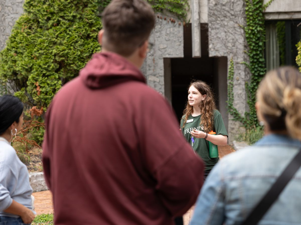 A tour guide standing outside with a crowd around them