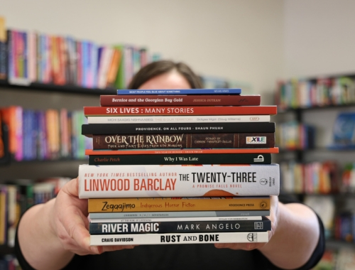 A person holding a stack of books up in front of their face