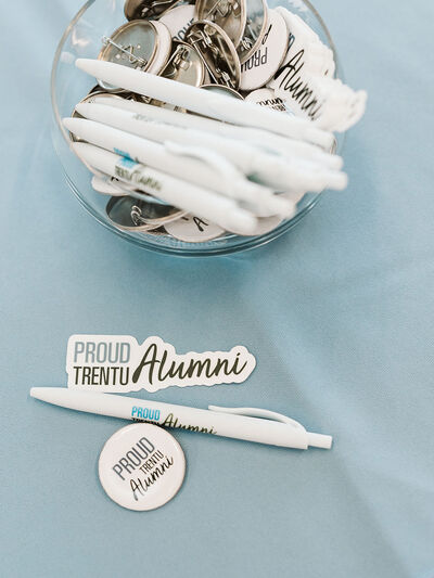 An alumni pin, sticker, and button