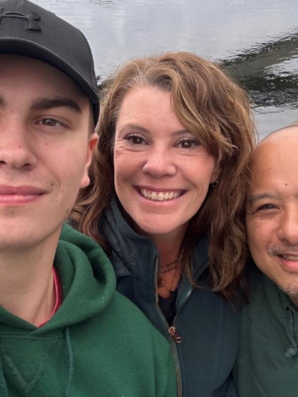 Angela Moore smiling next to her son and best friend