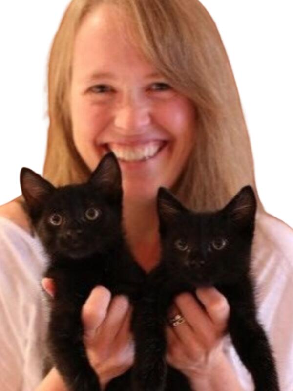 Karen Wickerson smiling and holding two black cats