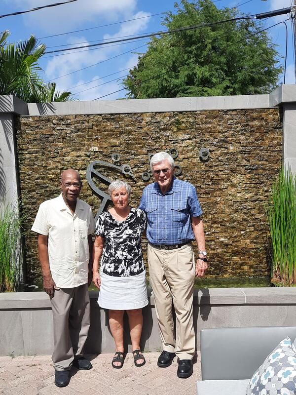 Three people standing outside smiling at the camera
