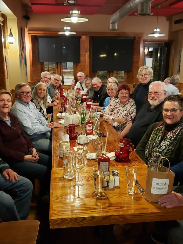 A group of people in a pub around a table smiling at the camera