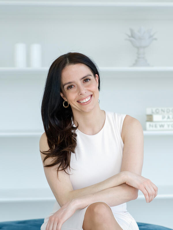 Woman in a white dress smiling at the camera