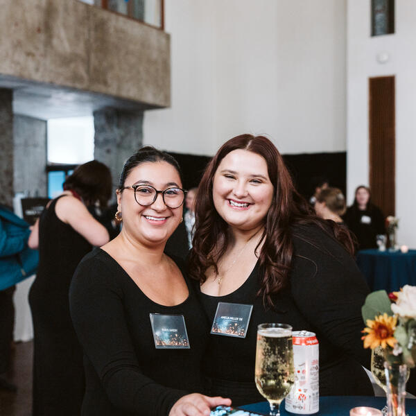 2 women smiling at event table