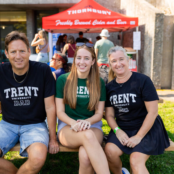 A mother and father wearing Trent shirts with their daughter wearing a Trent shirt